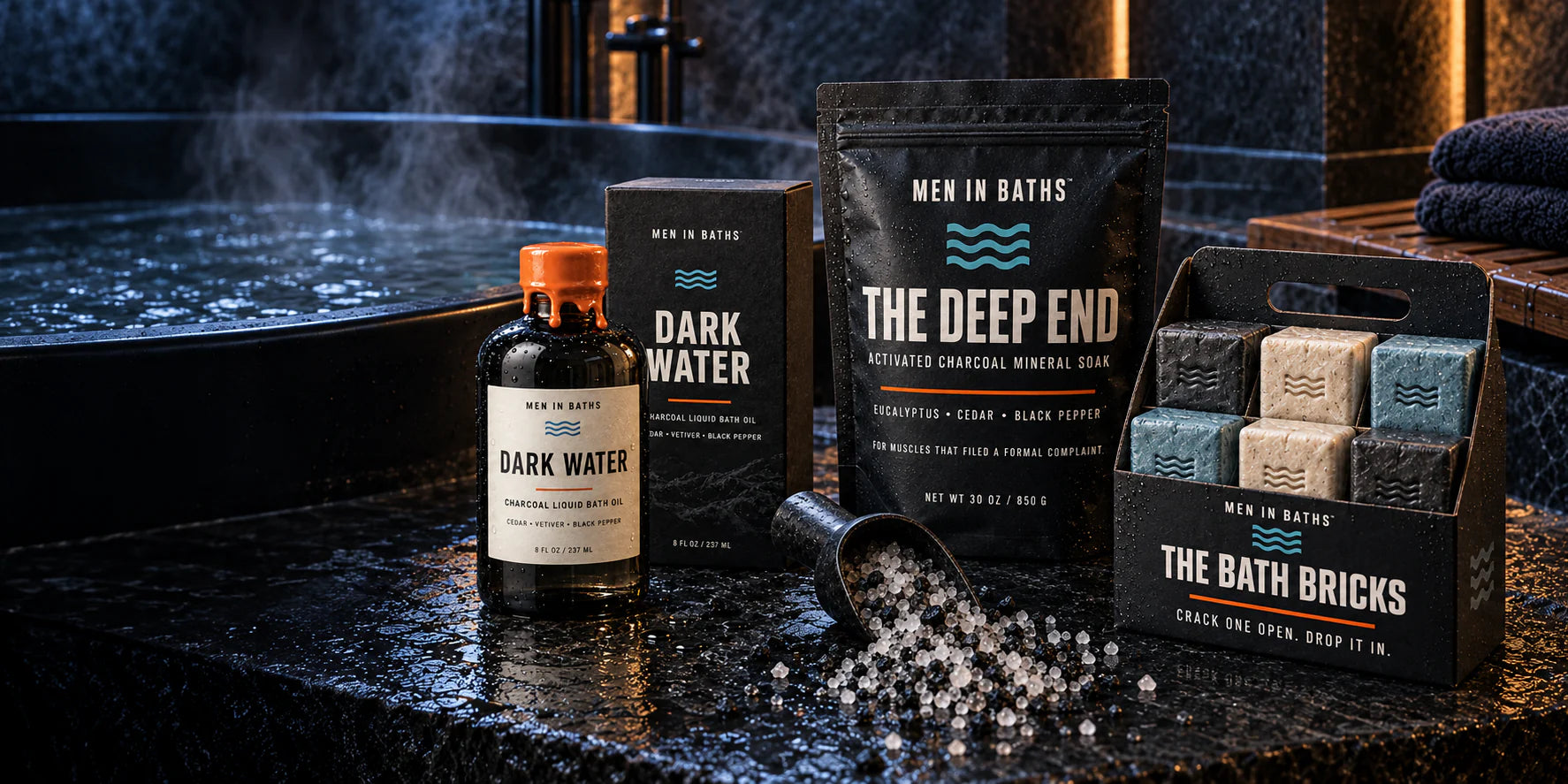 Dark Water bath oil, The Deep End mineral soak and six Bath Bricks beside a matte-black bathtub
